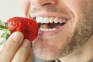 man eating strawberry