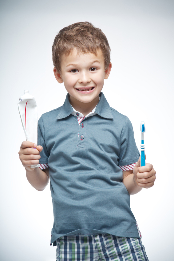 boy holding toothbrush and toothpaste